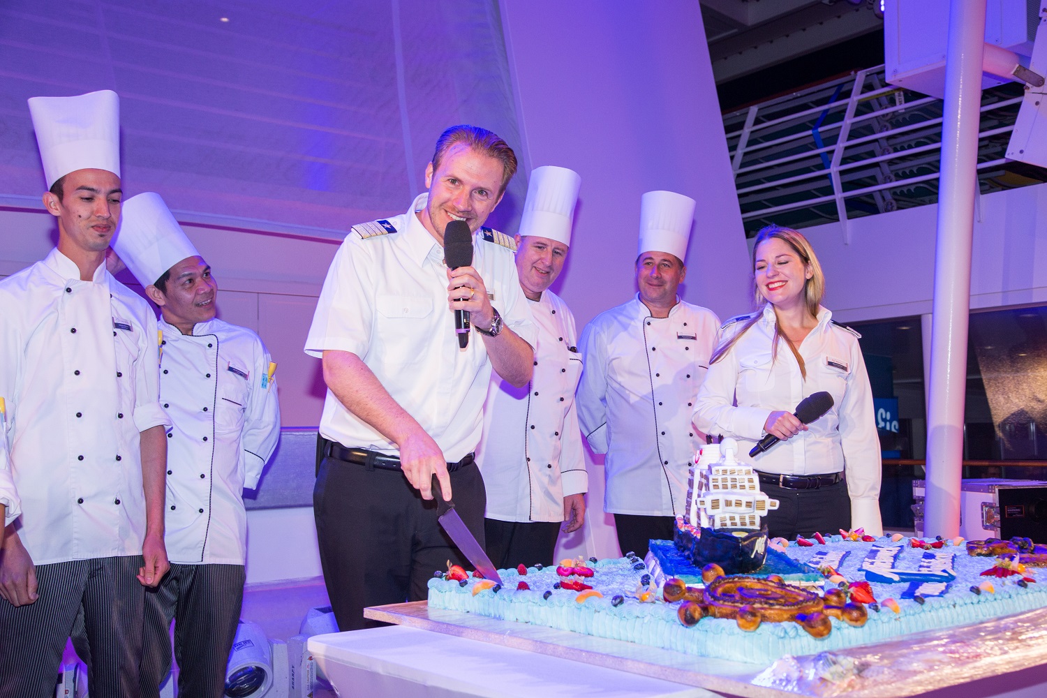 TUI Cruises Kapitän Simon Böttger schneidet die Geburtstagstorte der Mein Schiff 6 an