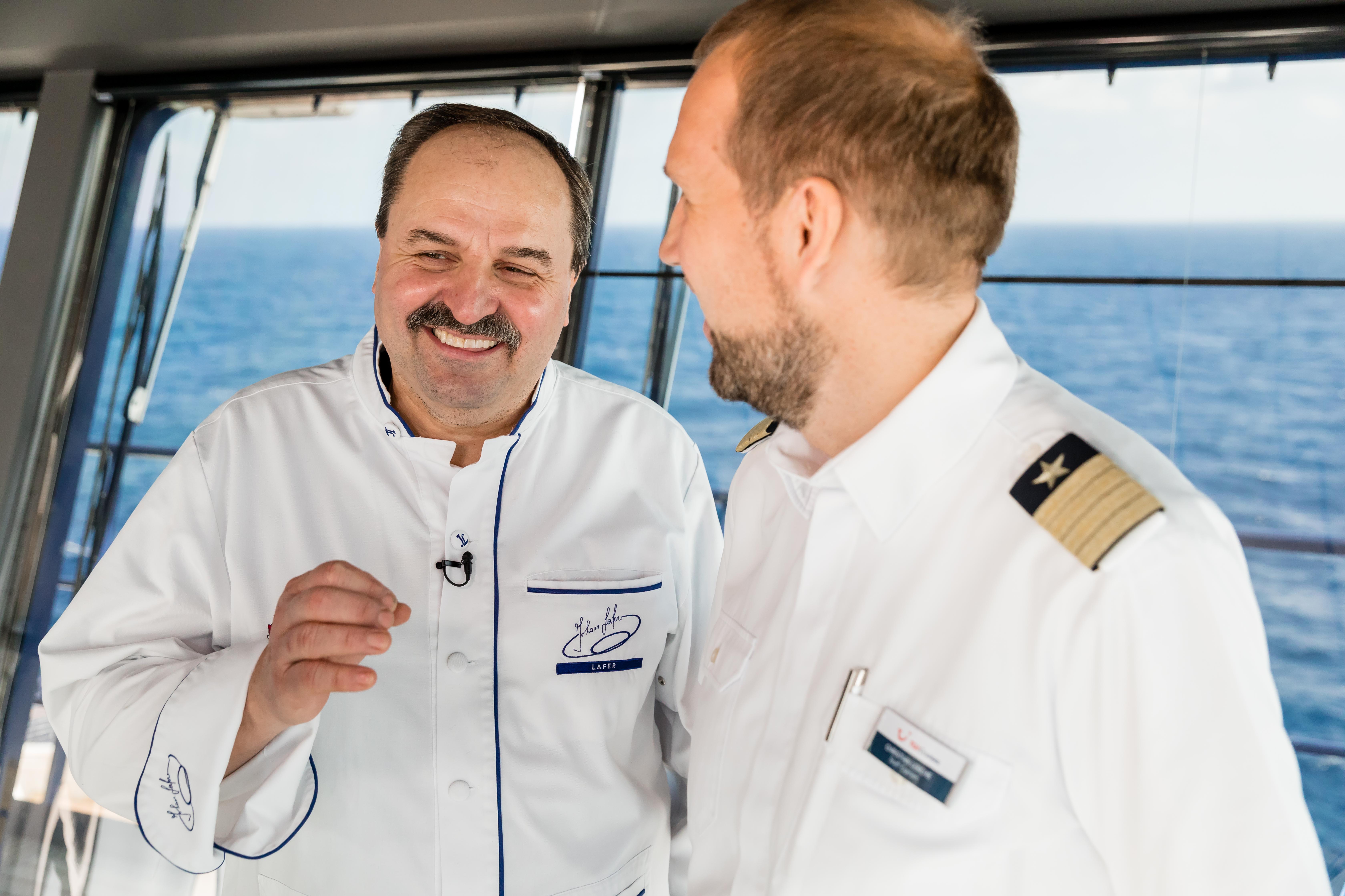 Sternekoch Johann Lafer im Gespräch mit einem TUI Cruises Staff Kapitän